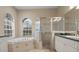 Inviting bathroom with tiled shower, soaking tub, double vanity, and large window with natural light at 2593 Colonel Ford Dr, Lakeland, FL 33813
