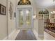 Inviting entryway with decorative glass doors, tile flooring, and views into the formal dining area at 2593 Colonel Ford Dr, Lakeland, FL 33813