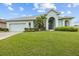 Charming home featuring a manicured lawn, complemented by lush landscaping and a welcoming light blue exterior at 2593 Colonel Ford Dr, Lakeland, FL 33813