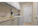 Functional laundry room with white cabinets, a sink, and modern washer and dryer units at 2593 Colonel Ford Dr, Lakeland, FL 33813