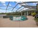 Beautiful pool and spa combo surrounded by a screened-in enclosure and lush landscaping at 2593 Colonel Ford Dr, Lakeland, FL 33813