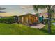 View of the backyard featuring a patio set and well-maintained lawn and a canal nearby at 3261 Fish Hawk Dr, Polk City, FL 33868