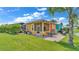 Rear exterior with lanai, lush landscaping, patio, and lake view at 3261 Fish Hawk Dr, Polk City, FL 33868