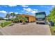 Exterior of home featuring a coach and brick driveway in a tropical setting at 3261 Fish Hawk Dr, Polk City, FL 33868