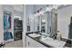 Stylish bathroom featuring double sinks, sleek fixtures, and a laundry area with stacked washer/dryer at 3287 Red Tail Hawk Dr, Polk City, FL 33868