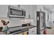 Close up of the modern kitchen with stainless steel appliances, white cabinets, and black countertops at 3287 Red Tail Hawk Dr, Polk City, FL 33868