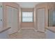 Bright bathroom area featuring dual closets, neutral tile flooring, and large window at 3487 Highland Fairways Blvd, Lakeland, FL 33810