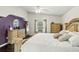 Cozy bedroom showcasing hardwood floors, natural light, and a decorative purple accent wall at 3568 Jade Ln, Mulberry, FL 33860