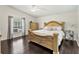 Spacious bedroom featuring hardwood floors, large window, and an intricately detailed king-size bed at 3568 Jade Ln, Mulberry, FL 33860