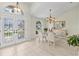 Open-concept entry showcasing glass front doors and an elegant dining area with decorative chandelier at 3568 Jade Ln, Mulberry, FL 33860