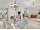 Elegant dining room with a decorative chandelier, a glass table, and views into the kitchen and living areas at 3568 Jade Ln, Mulberry, FL 33860