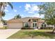 Charming single-story home featuring a manicured lawn, arched windows, and a welcoming double-door entrance at 3568 Jade Ln, Mulberry, FL 33860