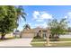 Inviting exterior view of a well-maintained home with a lush lawn, mature trees, and a spacious driveway at 3568 Jade Ln, Mulberry, FL 33860