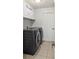 Modern laundry room with front load washer and dryer and neutral tile floor at 3568 Jade Ln, Mulberry, FL 33860