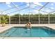 Relaxing screened-in pool area with a decorative fountain and lush greenery offering privacy at 3568 Jade Ln, Mulberry, FL 33860