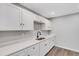 Modern kitchen with white cabinetry, quartz countertops, and a black faucet, perfect for cooking and entertaining at 3601 Avenue R Nw, Winter Haven, FL 33881