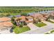 Aerial view of a community with well-maintained lawns and tile roofs surrounding a pond at 3980 Sunset Lake Dr, Lakeland, FL 33810