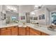 Bathroom featuring dual sinks, a large mirror, beautiful art, and wood cabinetry at 3980 Sunset Lake Dr, Lakeland, FL 33810