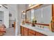 Bathroom showcasing a double sink vanity, large mirror, and a doorway to the bedroom at 3980 Sunset Lake Dr, Lakeland, FL 33810