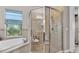 Bright bathroom boasts a separate bathtub and glass shower with a seat and handrails at 3980 Sunset Lake Dr, Lakeland, FL 33810