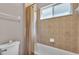 Standard bathroom with a shower-tub combo, tiled walls, and a small window for natural light at 3980 Sunset Lake Dr, Lakeland, FL 33810