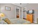 Cozy bedroom with a dresser and a door leading to the bathroom and a television at 3980 Sunset Lake Dr, Lakeland, FL 33810