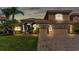 Charming tan two-story home with a brick driveway, lush lawn, and well-maintained landscaping at 3980 Sunset Lake Dr, Lakeland, FL 33810