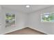 This bedroom features wood-look floors, white walls, and two windows at 408 Sycamore Sw St, Fort Meade, FL 33841