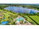 Aerial view of a community pool, lake, and surrounding lush greenery at 4125 Prima Lago Cir, Lakeland, FL 33810