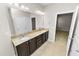 This bathroom has a double sink, granite counters, and dark wood cabinets at 4125 Prima Lago Cir, Lakeland, FL 33810