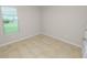 A simple bedroom has a single window overlooking the backyard at 4125 Prima Lago Cir, Lakeland, FL 33810