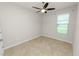 Neutral bedroom with tile flooring, ceiling fan, window, and white trim at 4125 Prima Lago Cir, Lakeland, FL 33810