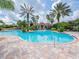 Beautiful community pool surrounded by palm trees and lounge chairs for residents to enjoy at 4125 Prima Lago Cir, Lakeland, FL 33810