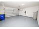Clean garage featuring epoxy flooring, white block walls, and garage door at 4125 Prima Lago Cir, Lakeland, FL 33810