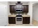 Kitchen with stainless steel appliances, granite countertops, tile backsplash, and dark wood cabinets at 4125 Prima Lago Cir, Lakeland, FL 33810