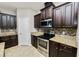 Modern kitchen featuring stainless steel appliances, granite countertops, and dark wood cabinets at 4125 Prima Lago Cir, Lakeland, FL 33810