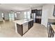 Kitchen featuring stainless steel appliances, granite countertops, kitchen island, and access to the living room at 4125 Prima Lago Cir, Lakeland, FL 33810