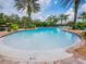Beautiful community pool surrounded by lush landscaping and palm trees under a bright sky at 4125 Prima Lago Cir, Lakeland, FL 33810