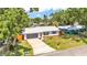 Beautiful home with a new metal roof, gray garage door, and lush greenery, creating a picturesque setting at 416 Bayou Rd, Winter Haven, FL 33884