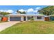Charming single-story home featuring a new metal roof, gray garage door and beautiful landscaping at 416 Bayou Rd, Winter Haven, FL 33884