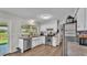 Well-lit kitchen featuring white cabinets, stainless steel appliances, and a sink with a view at 416 Bayou Rd, Winter Haven, FL 33884