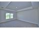A carpeted bedroom featuring a window and an eye-catching tray ceiling at 4306 Juliana Lake Dr, Auburndale, FL 33823