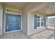 Inviting front porch with stylish blue door, brick floors, and view of home's exterior at 4306 Juliana Lake Dr, Auburndale, FL 33823