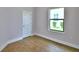 Empty bedroom featuring wood-look tile floors, a window, and neutral paint at 4312 Juliana Lake Dr, Auburndale, FL 33823