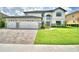 Beautiful two-story home featuring a three-car garage, brick driveway and pristine landscaping at 4312 Juliana Lake Dr, Auburndale, FL 33823