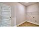 Laundry room with wood-look floors, washer and dryer hookups, and a wire rack for storage at 4312 Juliana Lake Dr, Auburndale, FL 33823