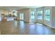 Open-concept living room boasting wood-look tile floors, large windows, and a view into the kitchen at 4312 Juliana Lake Dr, Auburndale, FL 33823