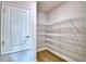 Spacious pantry with adjustable wire shelving and wood-look tile flooring for organized storage at 4312 Juliana Lake Dr, Auburndale, FL 33823