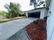 Long driveway leading to a detached garage, landscaped with red mulch and green foliage at 4535 Weston Ct, Bartow, FL 33830
