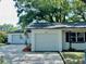 Exterior view of a home featuring white paint, a well-maintained yard, and an attached garage at 4535 Weston Ct, Bartow, FL 33830